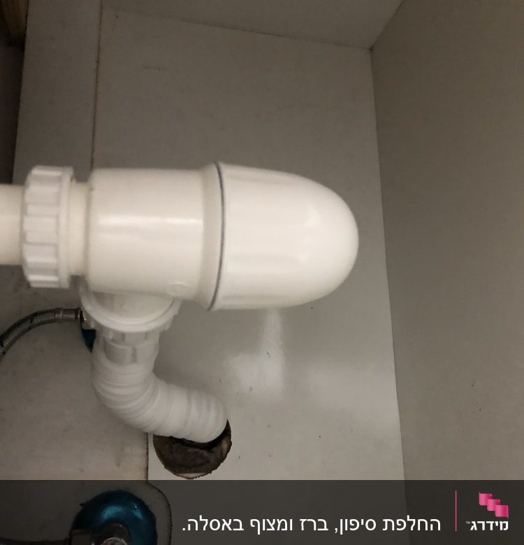 צינור פלסטיק לבן מתחת לכיור עם חיבורים